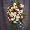 Standing floral spray with red roses, white lilies, and blue flowers