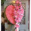 Large pink heart-shaped floral arrangement on an easel