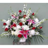 Large bouquet of red and pink flowers in a white vase