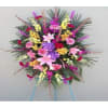 Large standing spray of mixed pink, purple, yellow, and white flowers