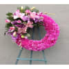 Pink floral wreath with lilies and roses on a stand