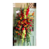 Tall standing floral spray with red, orange, and green flowers