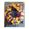 Large yellow and purple floral wreath on a stand
