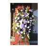 Tall standing floral spray with white and purple flowers on an easel