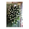 Large standing spray of white roses on an easel