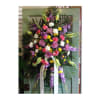 Tall standing spray of mixed pink, purple, white, and yellow flowers