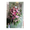 Tall pink and white floral standing spray on a green easel
