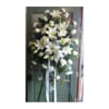Tall white lily standing spray on an easel with ribbon streamers