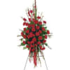 Tall standing spray of red carnations with ribbon on an easel