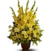 Tall yellow floral arrangement in a brown urn vase