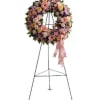 Floral wreath on a metal easel with a pink ribbon
