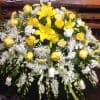 Yellow lilies and roses arranged with white flowers in a large spray