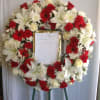 Heart-shaped wreath of red and white flowers on an easel