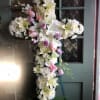 Cross-shaped floral spray with white lilies, daisies, and pink roses