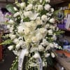 Large white funeral standing spray with roses and lilies