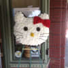 Hello Kitty-shaped floral display with a red bow on an easel