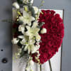 Heart-shaped red rose arrangement with white lilies and roses on an easel