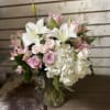 Pink and white bouquet with lilies, roses, and hydrangea in a glass vase