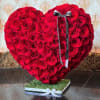 Heart-shaped arrangement of red roses with a ribbon on a square base