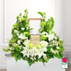 White lilies and green flowers arranged around a framed center and gold box