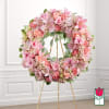 Pink floral wreath on a gold stand