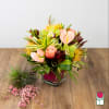 Tropical bouquet in a glass vase with pink anthuriums and orchids