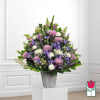 Mixed purple and white floral arrangement in a silver vase