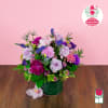 Lavender and pink flower arrangement in a green vase