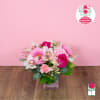 Pink and white mixed flower arrangement in a square glass vase