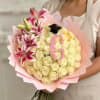 Bouquet of cream roses and pink lilies with a graduation cap topper