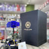 Single blue rose under a clear glass dome with black gift box and ribbon.