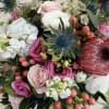 Mixed bouquet with pink and white flowers and a blue thistle bloom