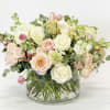 Pale blush and peach roses mingle with soft white lisianthus and airy