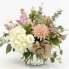 Mixed pastel bouquet in a clear glass vase with a burlap bow