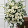 White floral funeral spray with roses and gerbera daisies on a stand