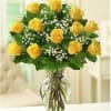 Bouquet of yellow roses with baby's breath in a clear glass vase