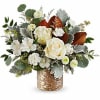 White roses and small white flowers in a woven basket vase
