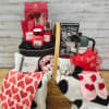 Gift basket with heart-patterned blankets, mug, candles, and beauty items