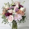 Pastel mixed flower bouquet in a clear glass vase