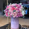 Large pink and lavender rose arrangement in a tall purple box