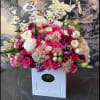 Large bouquet of pink, white, and purple roses in a white box