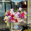 Large mixed bouquet of pink and purple roses in a white vase