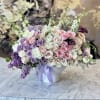 Large bouquet of pink, white, and lavender roses in a white vase