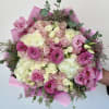 Pink and white bouquet of roses and lisianthus wrapped in pink paper