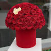Red rose arrangement in a red cylindrical box with a few white roses
