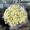 Large bouquet of cream and pale yellow roses wrapped in white tulle