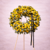 Large yellow rose wreath with black ribbon on a wooden easel stand