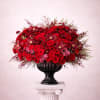 Large red rose arrangement in a black urn vase