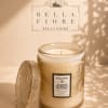 Decorative jasmine-scented candle in a glass jar with a patterned lid