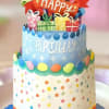 Decorated birthday cake with colorful gifts and a "Happy Birthday" topper